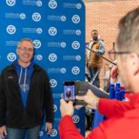 An alum getting his picture taken by another alum.